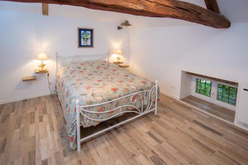 a bedroom with a bed and a wooden floor at La croix des vignes in Brossay