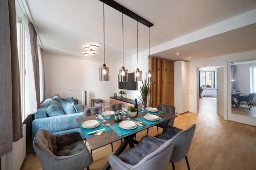 a living room with a table and a blue couch at Altstadt-App. Domblick! in Salzburg