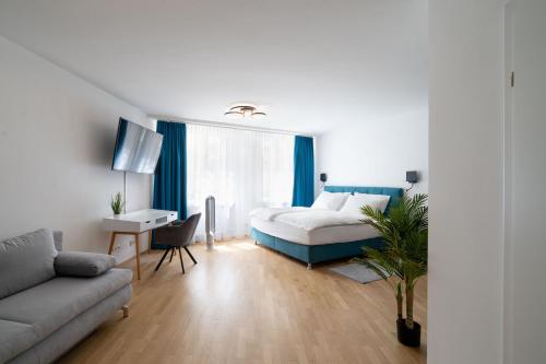 a bedroom with a bed and a desk and a couch at Altstadt-App. Domblick! in Salzburg