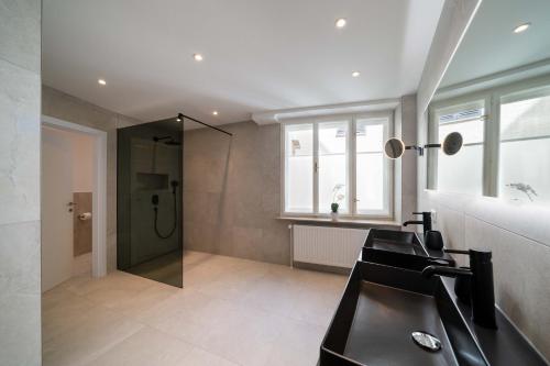 a bathroom with a shower and a black sink at Altstadt-App. Domblick! in Salzburg