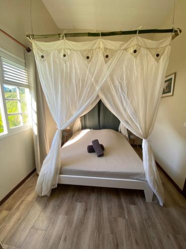 a bedroom with a bed with a bow tie on it at Chambre Roucou vue Mont Pelée in Le Morne Rouge