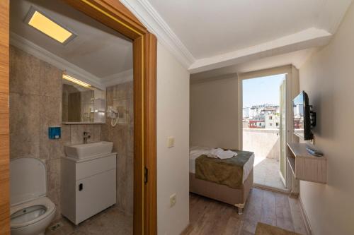 La salle de bains est pourvue de toilettes, d'un lavabo et d'une fenêtre. dans l'établissement Bazaar Hotels Old City, à Istanbul