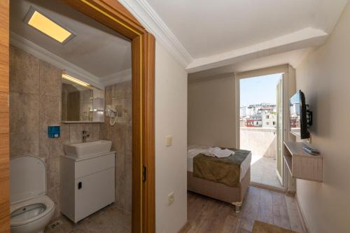 a bathroom with a toilet and a sink and a window at Bazaar Hotels Old City in Istanbul