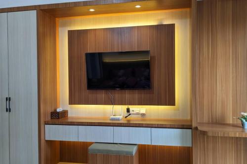 a room with a television on a wall at The cozy & luxury room in Podomoro City Deli Medan in Medan