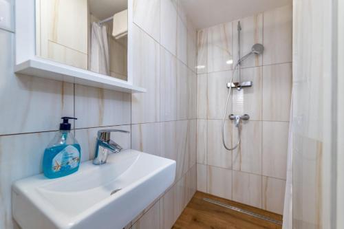 ein weißes Badezimmer mit Waschbecken und Dusche in der Unterkunft Cecilia in Baška