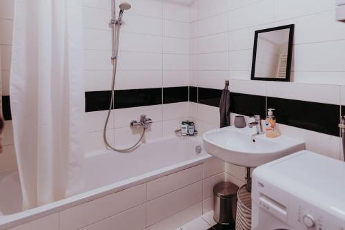 a white bathroom with a sink and a bath tub at Z'Argette Apartment - Free Parking @ Zagrebacka C. in Zagreb