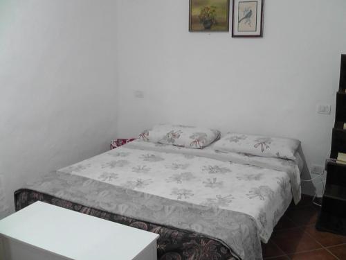 een klein bed in een kamer met een tafel bij Sardinia Experience in Villamassargia