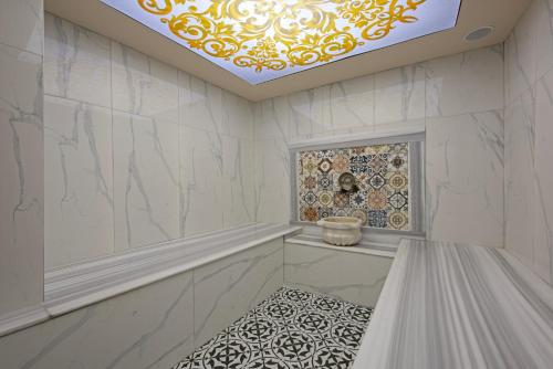 a bathroom with white marble walls and a ceiling at Büyük Hotel in Alanya