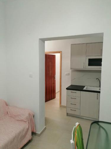 a bedroom with a bed and a kitchen with a sink at Katerina's House in Tympáki