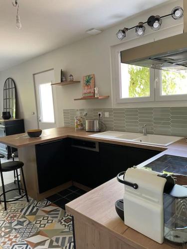 een keuken met een aanrecht, een wastafel en een raam bij Maison de village in Montoison