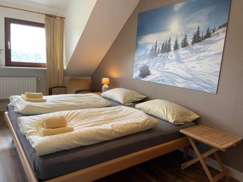 a bedroom with two beds and a painting on the wall at Apartment Haus Aktiv Top in Winterberg