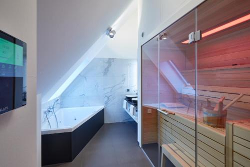 uma casa de banho com uma banheira e um lavatório em Erfurths Bergfried Ferien & Wellnesshotel em Hinterzarten