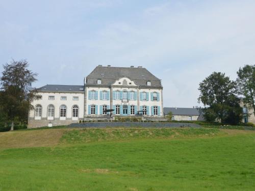 a large white house with a large grass field at Luxurious castle in Marchin with infrared sauna in Tharoul