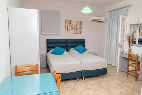a small bedroom with a bed and a table at Katerina Roza Studios - Heartfelt Hospitality in the City in Naxos Chora