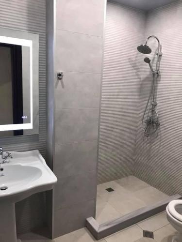 a bathroom with a shower and a sink at Hotel Light Palace in Batumi