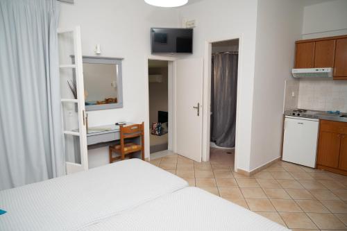 a bedroom with a bed and a kitchen with a desk at Katerina Roza Studios - Heartfelt Hospitality in the City in Naxos Chora