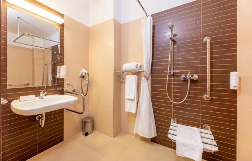 a bathroom with a sink and a shower at Hotel Krynica Conference & SPA in Krynica Zdrój