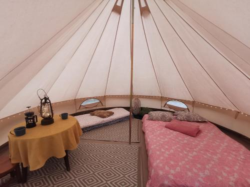 a room with two beds and a table in a tent at Kandle talu glämping in Selise