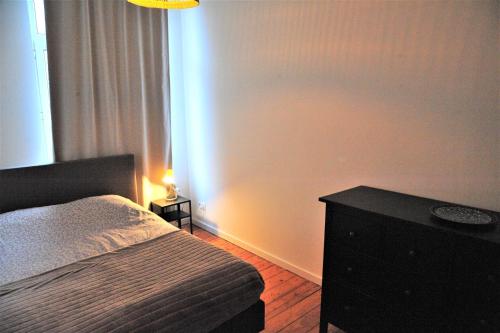 1 dormitorio con 1 cama y 1 mesa con lámpara en The Oasis apartment, 2 bedrooms antwerp South, en Amberes