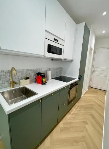 - une cuisine avec des placards blancs et verts et un évier dans l'établissement Appartement de charme - Hypercentre Gros Horloge, à Rouen
