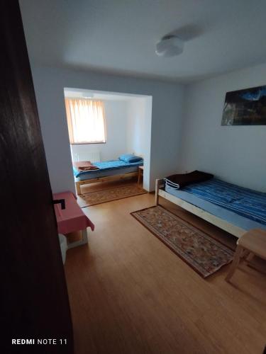 a small room with two beds and a window at Planinski dom Vrhe in Trbovlje