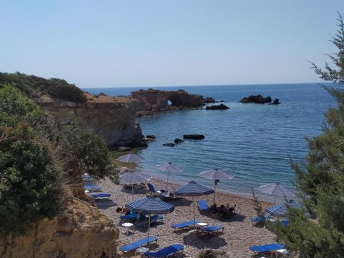 a beach with umbrellas and chairs and the water at Studio Aphrodite in Afiartis