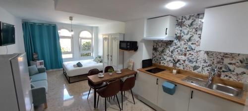 a small kitchen with a table and a living room at Apartamento Don Manuel in Rincón de la Victoria