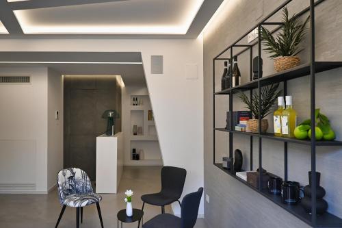 a living room with two chairs and a wall with shelves at El Concept Room in Brolo