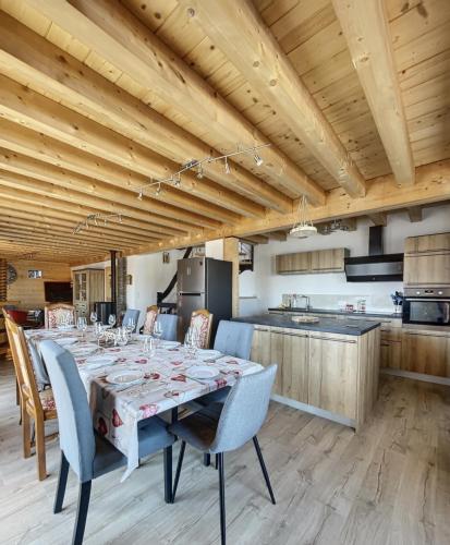 une cuisine et une salle à manger avec une table et des chaises dans l'établissement Chalet la Cochette, à La Toussuire