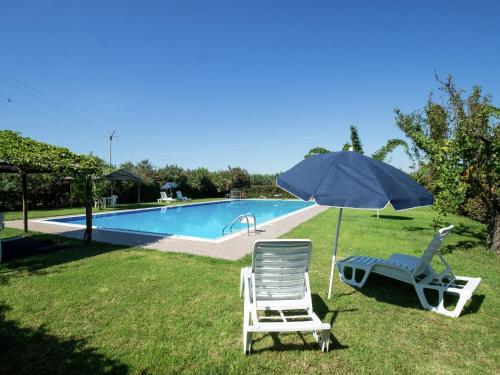 una sedia e un ombrellone accanto alla piscina di Holiday Home in Sciacca with Garden Swimming Pool Parking a Cartabubbo