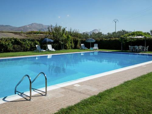 una grande piscina blu con sedie e ombrelloni di Holiday Home in Sciacca with Garden Swimming Pool Parking a Cartabubbo