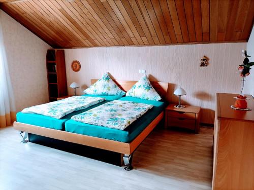 1 dormitorio con cama y techo de madera en Haus Heidrun, en Dolgesheim