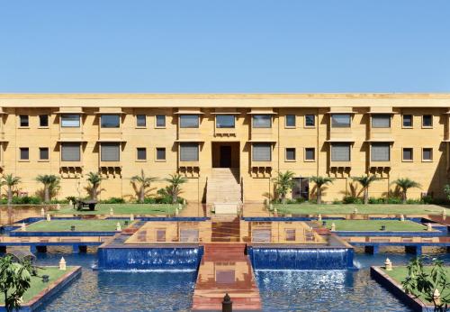 - un bâtiment avec une piscine en face dans l'établissement Jaisalmer Marriott Resort & Spa, à Jaisalmer