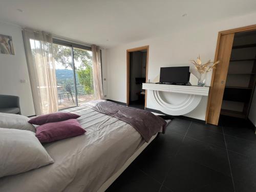 1 dormitorio con 1 cama con chimenea y ventana en Villa l’écrin du Rayol en Rayol-Canadel-sur-Mer
