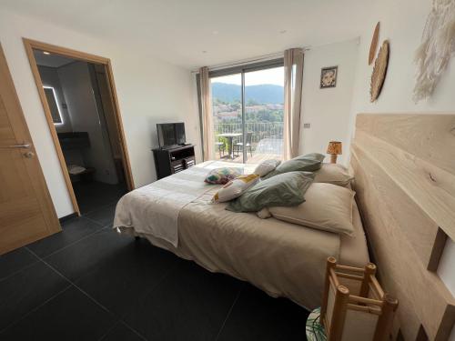 a bedroom with a large bed with a large window at Villa l’écrin du Rayol in Rayol-Canadel-sur-Mer
