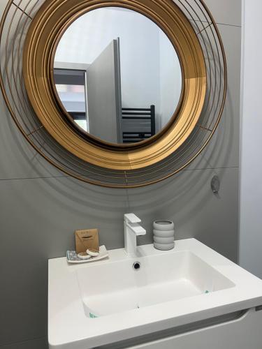 La salle de bains est pourvue d'un lavabo blanc et d'un miroir. dans l'établissement Lucky Number, à Sinaia