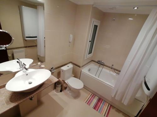 een badkamer met een wastafel, een toilet en een bad bij Downtown apartments in Bansko