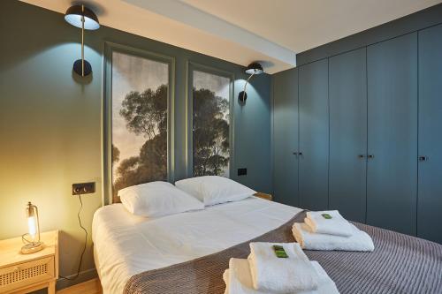 une chambre avec un grand lit avec des serviettes dessus dans l'établissement Residense Montmartre by Studio prestige, à Paris