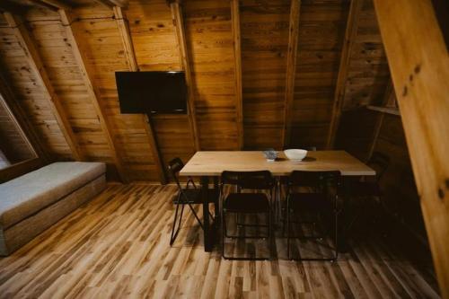 una habitación con mesa y sillas en una cabaña en Mesa Summer House en Zakrzewo