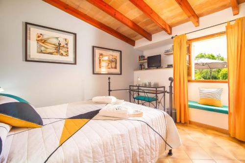 a bedroom with a bed and a window at Can Vadell in Pollença