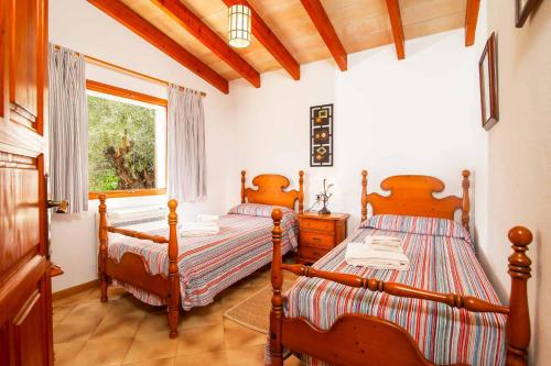 a bedroom with two beds and a window at Can Vadell in Pollença