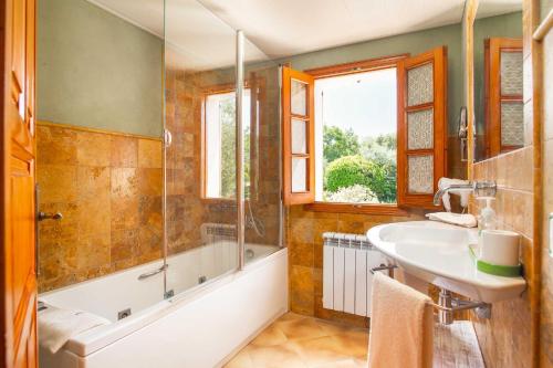 a bathroom with a tub and a sink and a shower at Can Vadell in Pollença