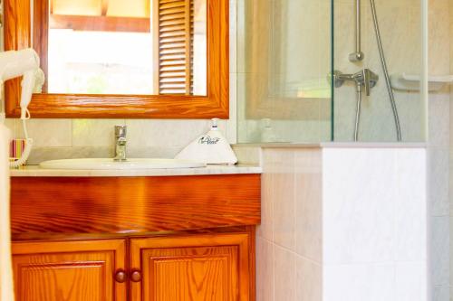a bathroom with a sink and a mirror and a shower at Can Vadell in Pollença