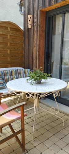 une table blanche avec une plante en pot sur une terrasse dans l'établissement Auprès du château 2, à Brézé
