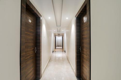 a hallway with wooden doors and a hallway with a corridor at FabHotel Bless Inn in Allahābād