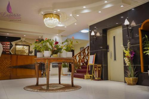a lobby with a table with potted plants on it at فندق البيت الصغير - Lapetite Maison Hotel in Baghdad