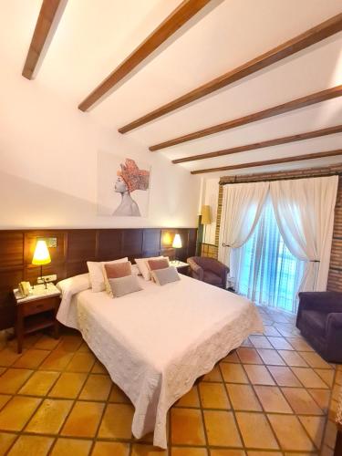a bedroom with a large white bed in a room at Hotel Don Gonzalo in Montilla