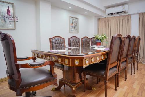 a conference room with a wooden table and chairs at فندق البيت الصغير - Lapetite Maison Hotel in Baghdad