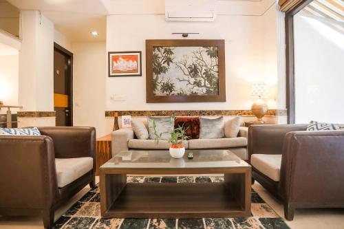 a living room with couches and a coffee table at FabHotel Rivlet Residency in Gurgaon