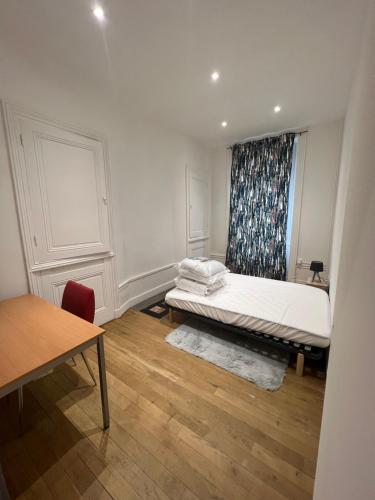 um pequeno quarto com uma cama e uma janela em Appartement T4 Jean-Jaurès em Saint-Étienne